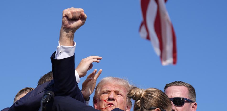 El candidato presidencial republicano, el expresidente Donald Trump, está rodeado por agentes del Servicio Secreto de Estados Unidos en un mitin de campaña