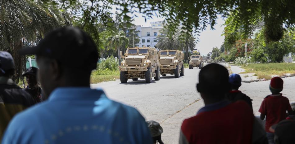 Los residentes observan vehículos blindados que transportan a agentes de policía de Kenia que forman parte de una fuerza multinacional respaldada por la ONU en Puerto Príncipe, Haití, el miércoles 17 de julio de 2024.