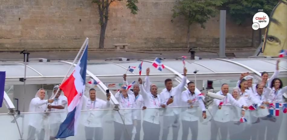 La delegación dominicana exhibe orgullosa su bandera en la lancha en que desfiló en el Río Sena.