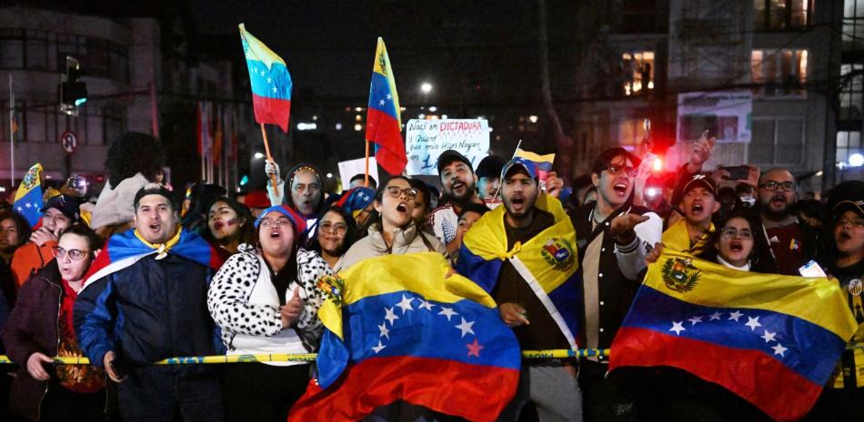 Los venezolanos que viven en Chile y los opositores del presidente venezolano Nicolás Maduro se reúnen frente al consulado de Venezuela en Santiago, Chile.