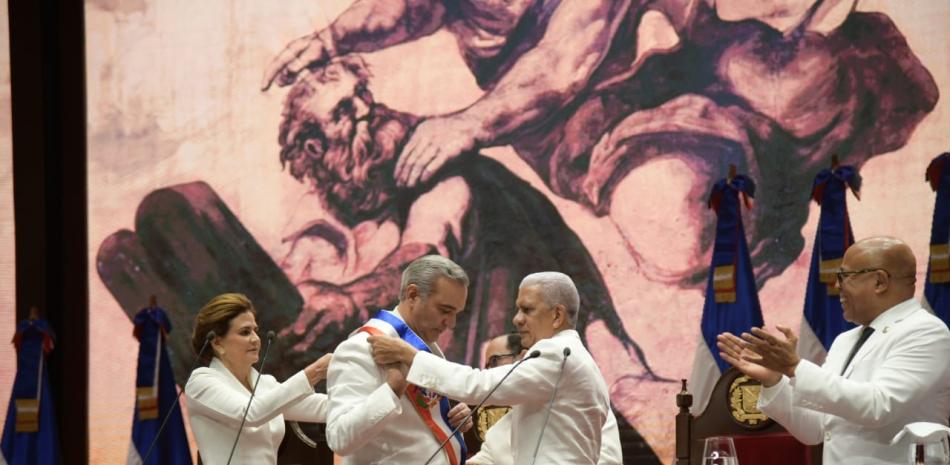 El presidente del Senado, Ricardo de los Santos, coloca la banda presidencial a Luis Abinader.