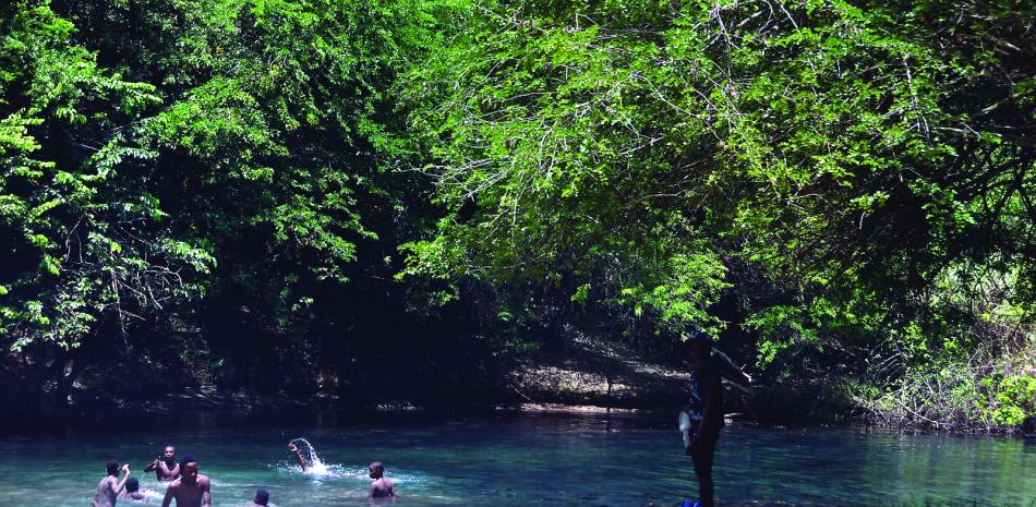 Niños y adolescentes disfrutan de las aguas cristalinas de un manantial en El Cachón de la Rubia.