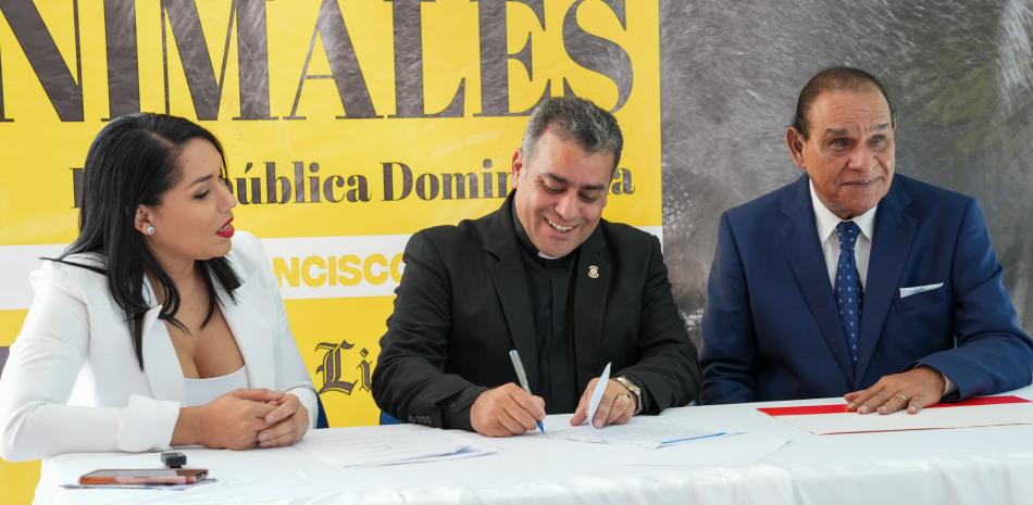 El rector de la UCNE, Isaac García, firma el pacto junto a Miguel Franjul y Lorenny Solano.