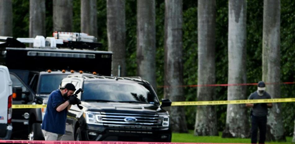 n agente del FBI toma una fotografía de la evidencia de la escena del crimen afuera del Trump International Golf Club en West Palm Beach, Florida, el 15 de septiembre de 2024, luego de un tiroteo en el campo de golf del ex presidente estadounidense Donald Trump.