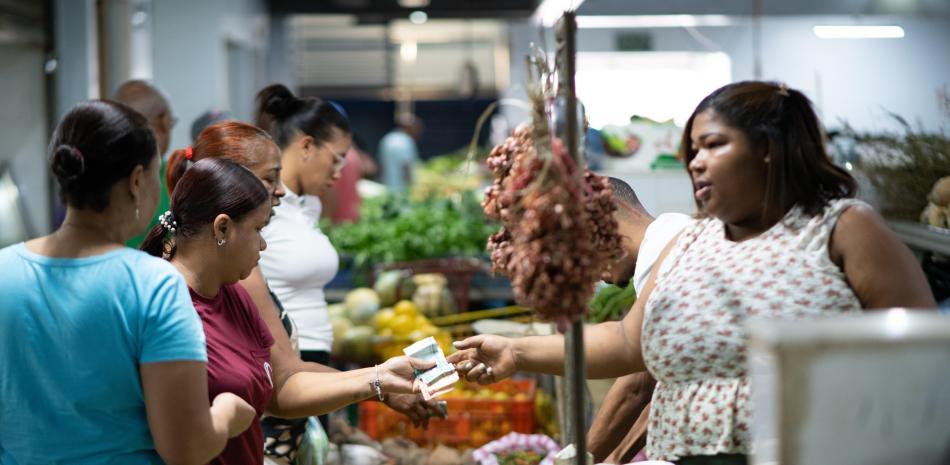 Personas compran alimentos de primera necesidad en un mercado del Distrito Nacional.