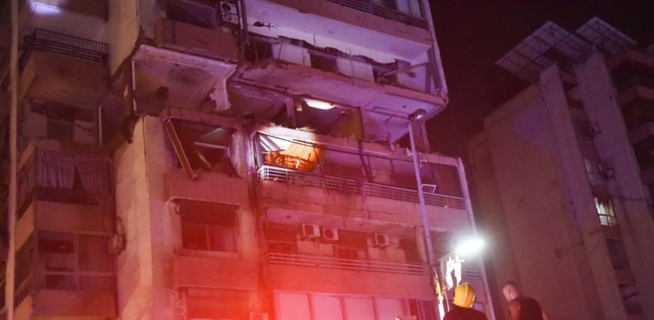 Los bomberos revisan el balcón de un edificio de apartamentos afectado por un ataque aéreo israelí en el distrito de Cola de Beirut, el 30 de septiembre de 2024.