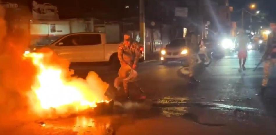 Fotografía muestra militar apagando fuego de protesta en San Francisco de Macorís.