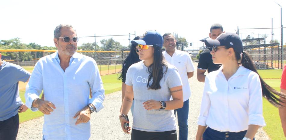 El Comisionado Nacional de Béisbol, Junior Noboa, recorre una de las academias de béisbol en el país. Junto a él en primer plano figuran María Villa Castaño y Natalia Bermeo.