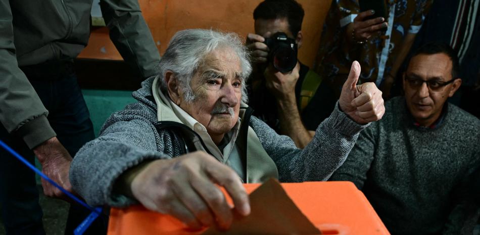 El expresidente uruguayo, José Mujica, levanta el pulgar mientras emite su voto en un colegio electoral en Montevideo