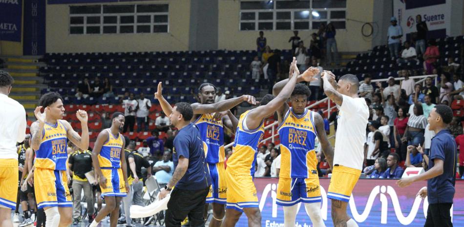 Varios jugadores de Mauricio Báez celebran la conquista del triunfo este domingo ante el Rafael Barias por estrecho margen de 79-75.