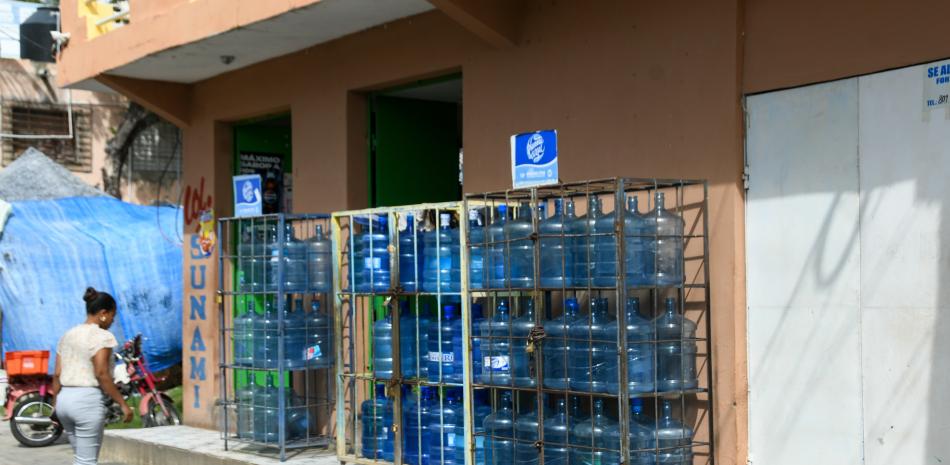 Botellones de agua para consumo humano expuesta a la venta al descubierto en un anaquel de colmado en Santo Domingo Este.