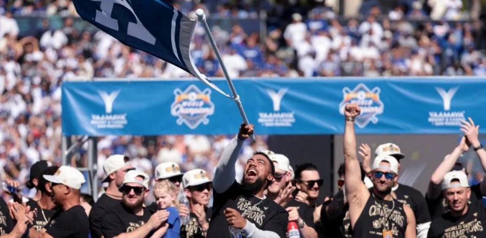 Teoscar Hernández portando una bandera durante la celebración de los Dodgers del cetro alcanzado en la Serie Mundial ante los Yankees