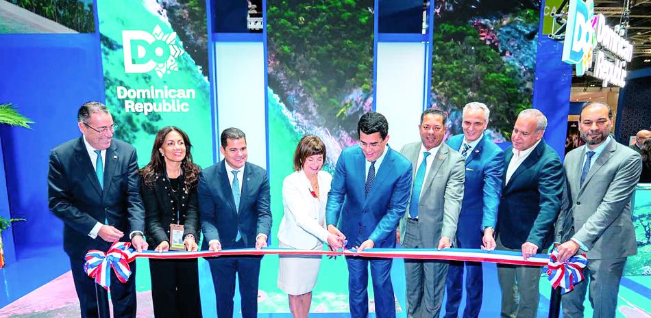 El ministro David Collado y la presidenta de la WTTC, Julia Simpson, en compañia de ejecutivos bancarios e invitados especiales, cortan la cinta del stand dominicano.