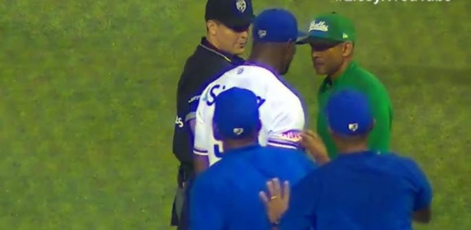 Radhames Liz, lanzador del Licey al momento de interpelar a Fernando tatis, dirigente de las Estrellas, quien había reclamado que el pitcher tenía una manga rasgada en su camiseta.