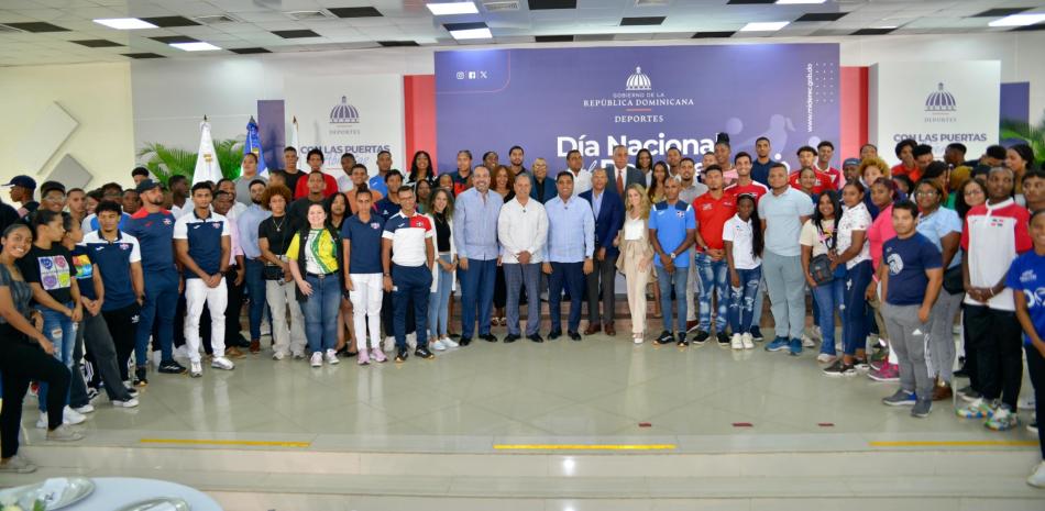 El ministro de Deportes, Kelvin Cruz, junto al presidente del Comité Olímpico Dominicano, Garibaldy Bautista; Alberto Rodríguez, director de Inefi; Luis Mejía y José P. Monegro, titulares de Centro Caribe Sports y el Comité Organizador de los Juegos Centroamericanos y del Caribe 2026, respectivamente, y el grupo de atletas.