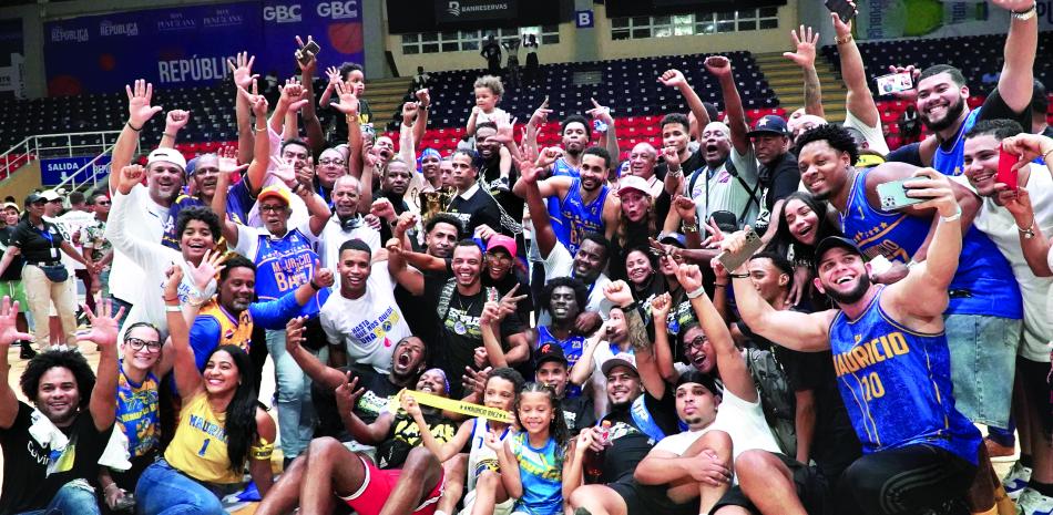 Jugadores, entrenadores y simpatizantes del club Mauricio Báez celebran junto con la corona de campeón del TBS distrito en el séptimo partido frente a Bameso.