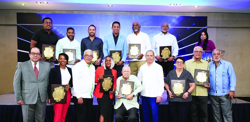 Franklin de la Mota, Dionisio Guzmán y Garibaldi Bautista encabezan la entrega de placa a los deportistas que serán exaltados el domingo. Detrás, desde la izquierda, Joel Ramírez, Félix Díaz, Víctor Estrella, Octavio Dotel, Fernando Hernández y Cristian Cruz. Abajo y en el mismo orden, De la Mota, Ana Villanueva, Guzmán, Wendy Santana, Luis Ángel Montalvo, Bautista, Mayo Sibilia, José Armando Castillo y Pedro Gómez.