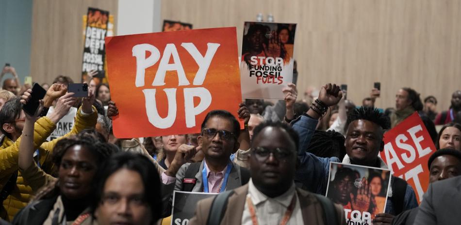 Activistas participan en una manifestación por el financiamiento climático durante la cumbre climática COP29 de Naciones Unidas, el sábado en Bakú, Azerbaiyán. En el cartel dice "Paguen".