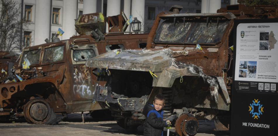 Un niño monta en patineta junto a una exposición de vehículos rusos destruidos en la plaza Mykhailivska del centro de Kiev, Ucrania, el martes 22 de octubre de 2024.