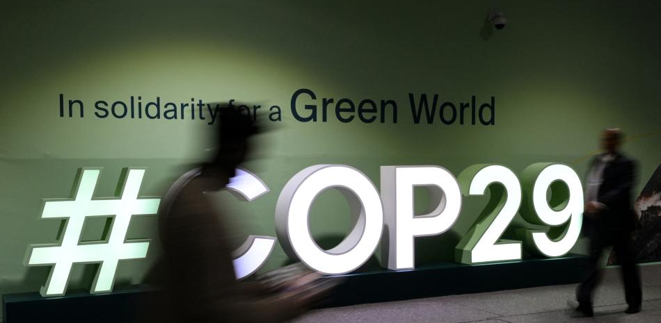 Los asistentes pasan junto al logotipo de la COP29 durante la Conferencia de las Naciones Unidas sobre el Cambio Climático (COP29) en Bakú, Azerbaiyán, el 21 de noviembre de 2024.