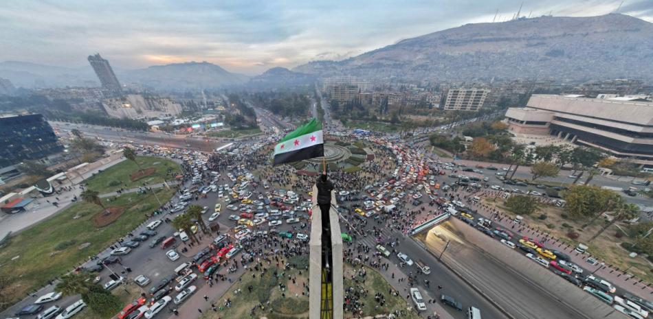 Un hombre sirio ondea la bandera siria de la era de la independencia en la plaza central de los Omeyas de Damasco.