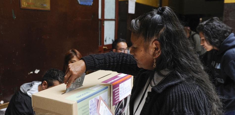 Una mujer deposita su voto en un colegio electoral durante las elecciones judiciales en La Paz el 15 de diciembre de 2024. - Más de 7,3 millones de bolivianos están llamados a votar obligatoriamente este domingo para elegir a sus máximas autoridades de justicia en una elección anómala en la que la mayoría de departamentos no podrán renovar a todos sus representantes.