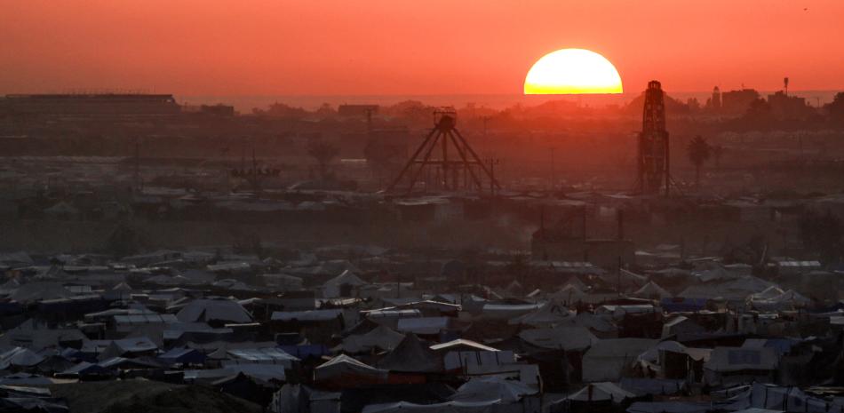 El sol se pone detrás de las tiendas de campaña que albergan a los palestinos desplazados por el conflicto en el complejo de la ciudad residencial de Hamad en el norte de Khan Yunis, en el sur de la Franja de Gaza, el 22 de diciembre de 2024, en medio de la guerra en curso en el territorio palestino entre Israel y Hamás.