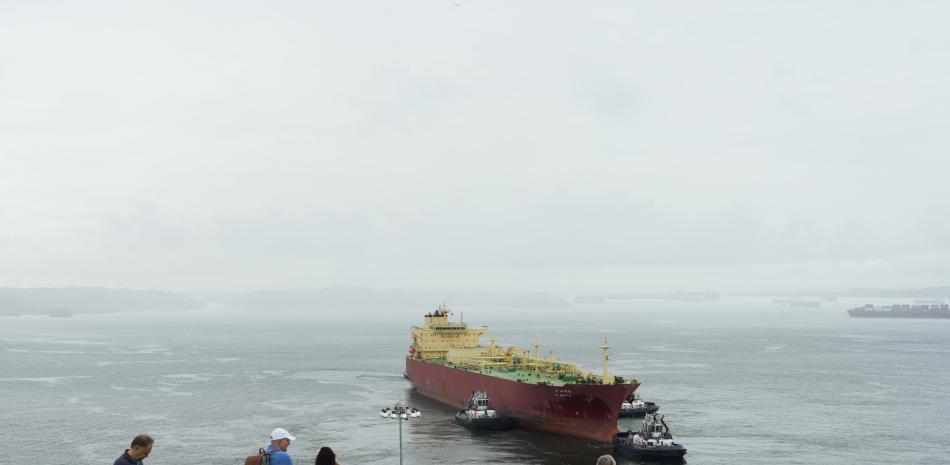 Turistas observan al carguero panameño G. Arete navegando por las esclusas de Agua Clara del Canal de Panamá en la ciudad de Colón, Panamá, el 28 de diciembre de 2024. - El 31 de diciembre de 2024, Panamá celebrará el 25 aniversario de la soberanía sobre el Canal.