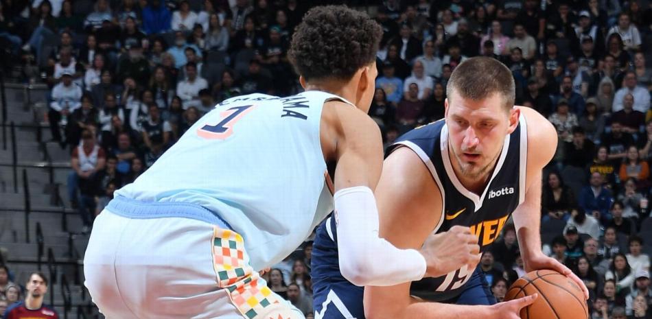 Nicolas Jokic busca marcar dos puntos frente a la oposición Víctor Wembanyama en el partido que los Nuggets se impusieron a los Spurs.