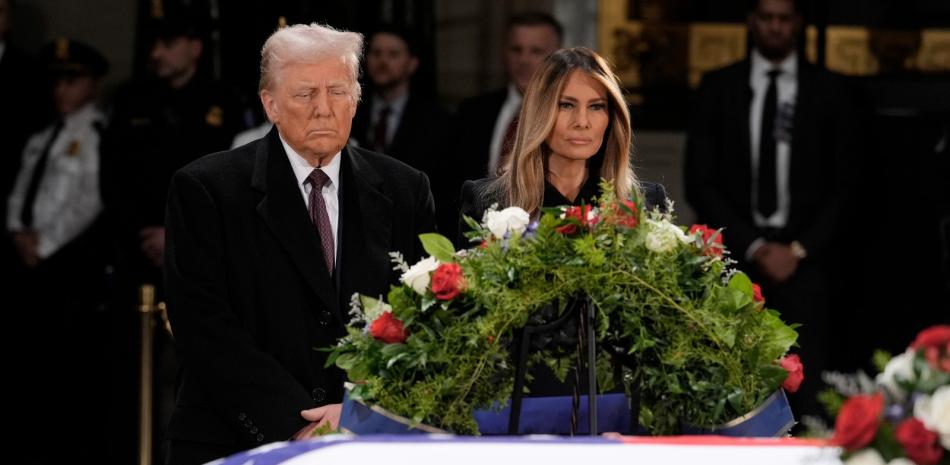 El presidente electo Donald Trump y su esposa, Melania Trump, frente al féretro del expresidente Jimmy Carter durante su funeral en el Capitolio federal, ayer.