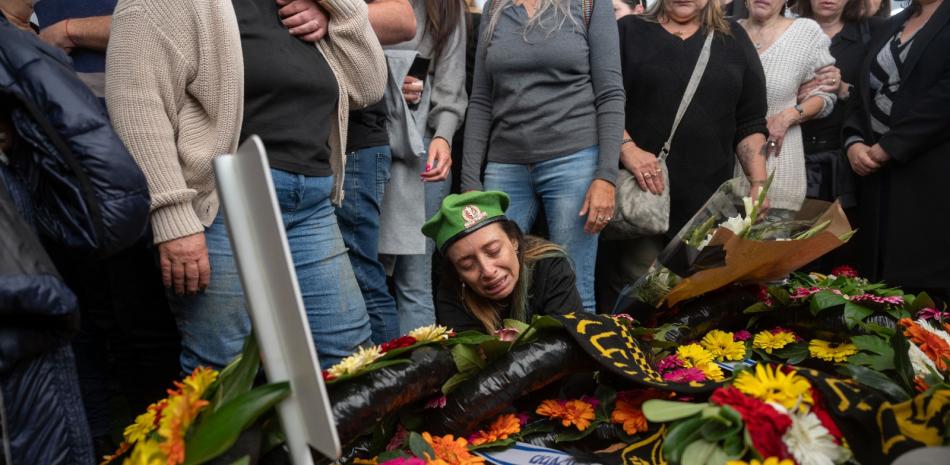 Gali, la madre del soldado israelí Sargento Yahav Maayan muerto en combate en la Franja de Gaza, junto a la tumba de su hijo durante su funeral en un cementerio militar en Modiin, Israel, ayer.