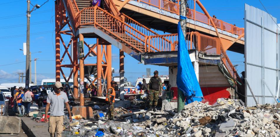 Comerciantes caminan por los escombros de sus locales