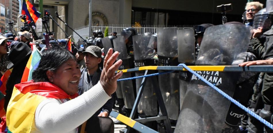 Un partidario de Evo Morales, hace gestos frente a agentes de la policía antidisturbios durante la marcha "Comunal por la Vida" contra el gobierno de Luis Arce, ayer.