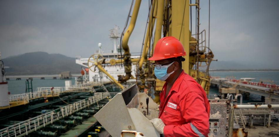 Un trabajador de la petrolera estatal venezolana PDVSA mira el petrolero Fortune, de bandera iraní, mientras atraca en la refinería El Palito en Puerto Cabello, en el estado norteño de Carabobo.