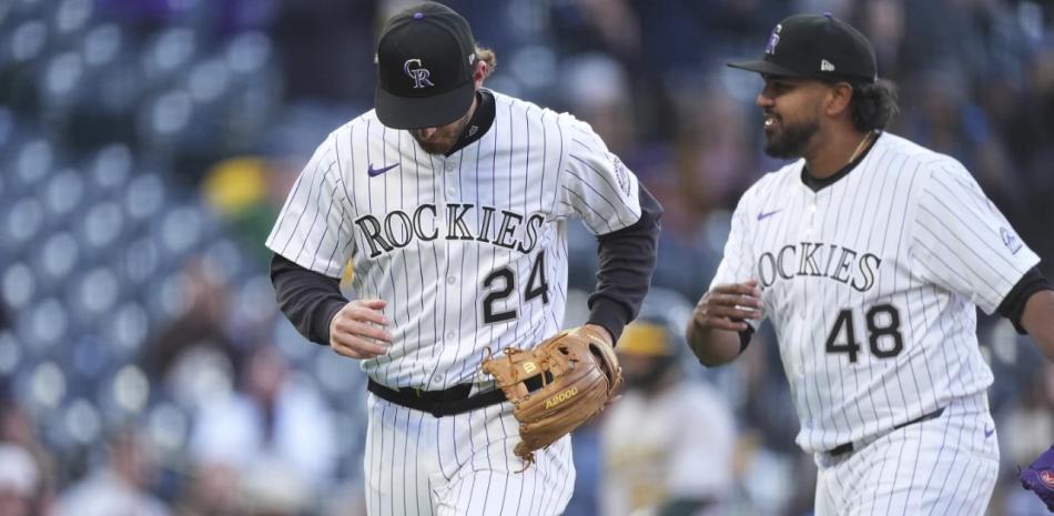 El lanzador venezolano de los Rockies, Germñan Márquez, felicita al antesalista Ryan McMahon, quien inició la triple matanza en la segunda entrada del choque ante Oakland.