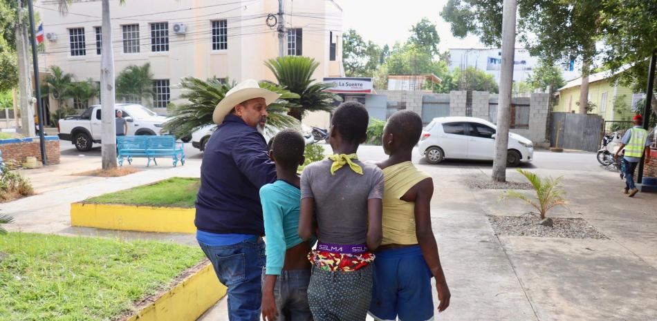 Alcalde de Dajabón, Santiago Riverón, sosteniendo a  3 niños haitianos para sacarlo de la provincia