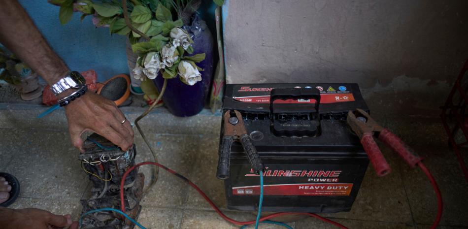 Ángel Rodríguez usa un transformador de una vieja televisión para cargar una batería ante los apagones de luz en su casa en el barrio de Bahía en La Habana, Cuba, el lunes 26 de mayo de 2025.