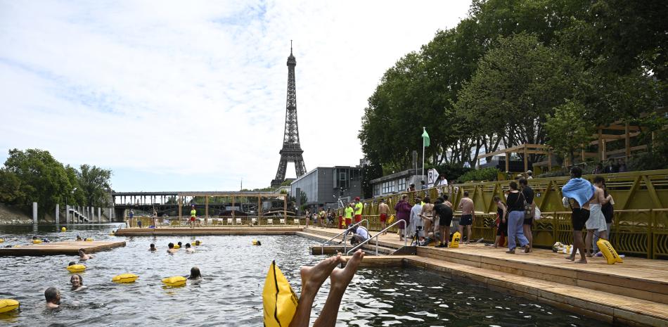 Un nadador se zambulle en el área de baño segura Grenelle, en el río Sena, el día de su inauguración, frente a la Torre Eiffel en París, el 5 de julio de 2025.