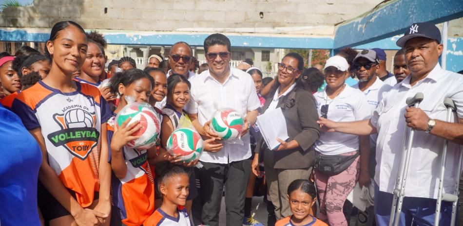 El alcalde Dío Astacio, acompañado del director de Deporte del Ayuntamiento Santo Domingo Este, mientras entregaba balones para la práctica del voleibol a uno de las academias de Los Mina.