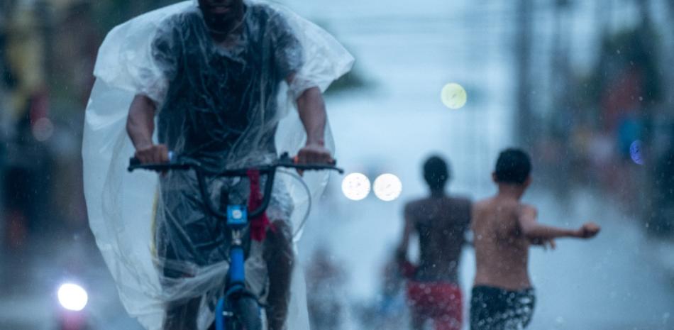 Niños juegan en la lluvia.