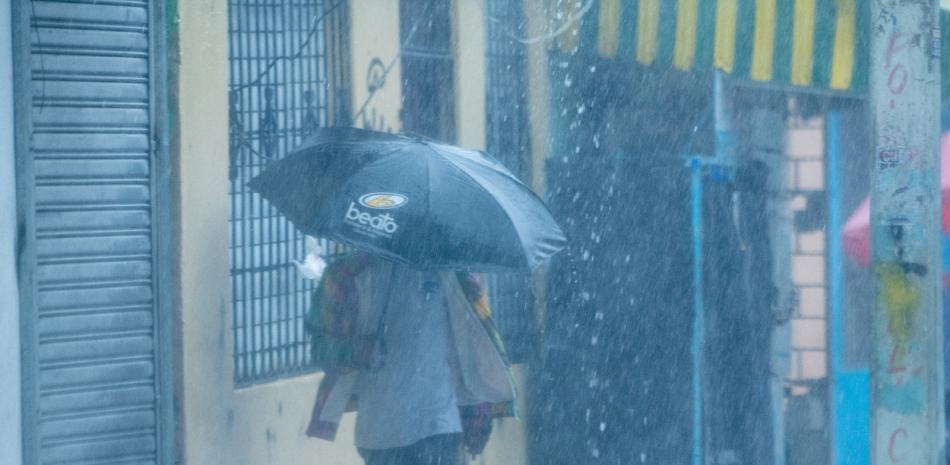 Una persona se protege de una lluvia fuerte con un paraguas