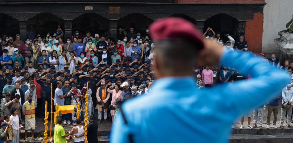 Policías saludan mientras realizan una guardia de honor en honor a su compañero, fallecido en medio de los disturbios durante las protestas anticorrupción, antes de su cremación en el crematorio de Pashupati en Katmandú el 12 de septiembre de 2025.