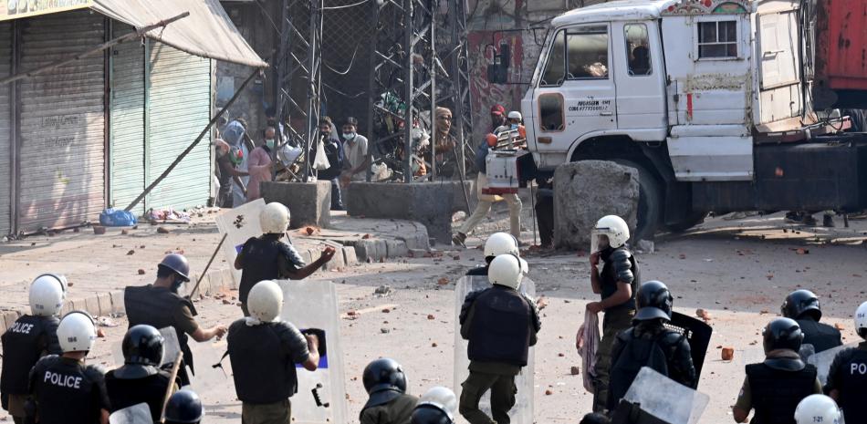Activistas del partido Tehreek-e-Labbaik Pakistan (TLP) se enfrentaron con la policía después de que las autoridades bloquearan la carretera con contenedores en Lahore el 10 de octubre de 2025, antes de su marcha pro palestina hacia Islamabad. (Foto de Arif ALI