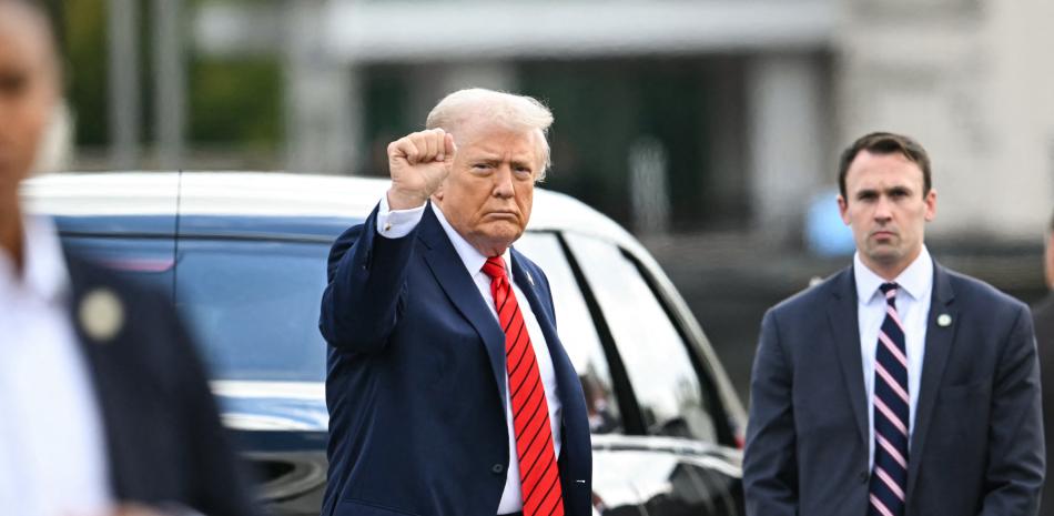 El presidente  Donald Trump hace un gesto al salir de su caravana para caminar hacia el Marine One tras su salida del Centro Médico Militar Nacional Walter Reed tras un chequeo médico en Bethesda, Maryland, el 10 de octubre de 2025.