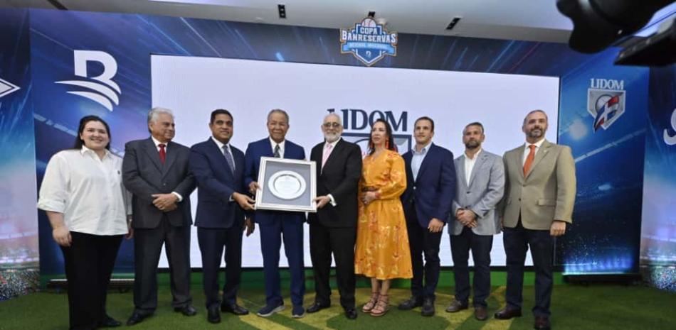 Vitelio Mejía y Kelvin Cruz entregan la placa conmemorativa a la dedicatoria del torneo a Juan Marichal. Les acompañan, de izquierda a derecha, Marialina Feris Abreu. Winston Llenas, Juan Francisco Puello Herrera, Kristen Castro, Alfredo Acebal, Eduardo Najri y Jorge Sturla.