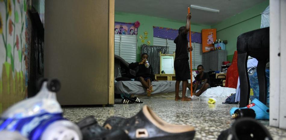 Tres niños evacuados de sus hogares por la tormenta Melissa conversan esta mañana en el albergue que los refugia en el Distrito Nacional
