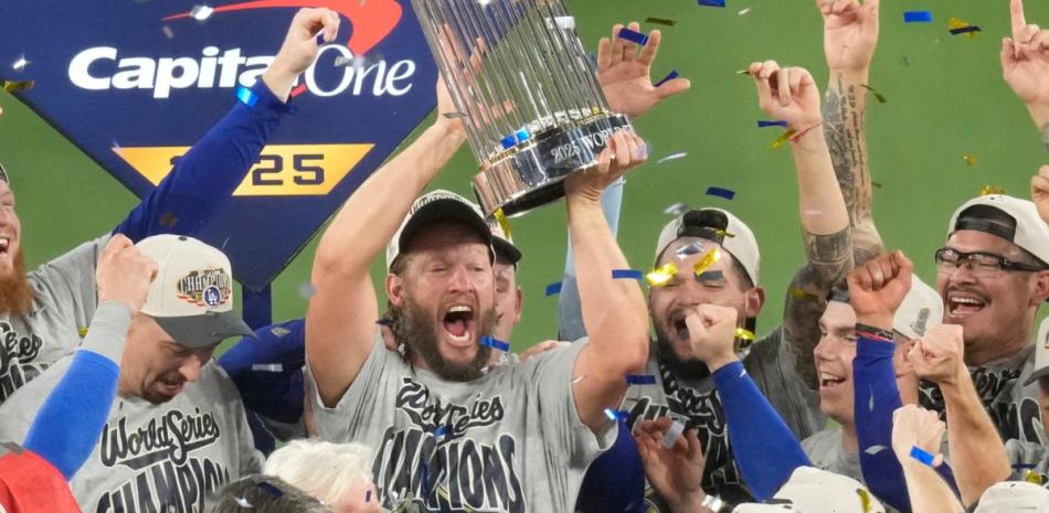 Clayton Kershaw levanta el trofeo de campeón que acredita a los Dodgers doble monarcas de la Serie Mundial.
