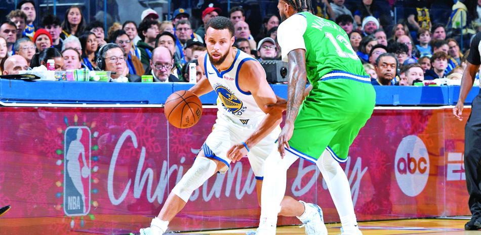 Stephen Curry busca anotar dos puntos en el partido en que los Warriors se impusieron a los Mavericks