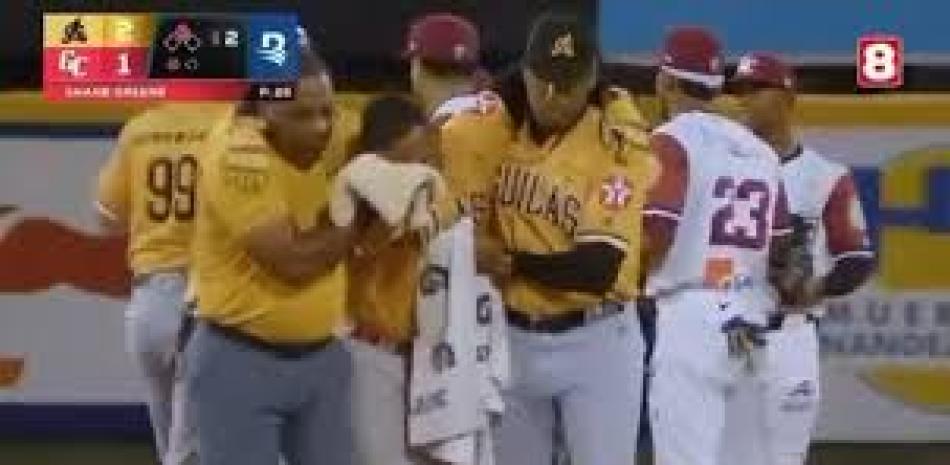 Alberto Rodríguez es ayudado a salir del terreno por dos instructores de las Aguilas luego de recibir un golpe en el ojo izquierdo mientras corría hacia la intermedia