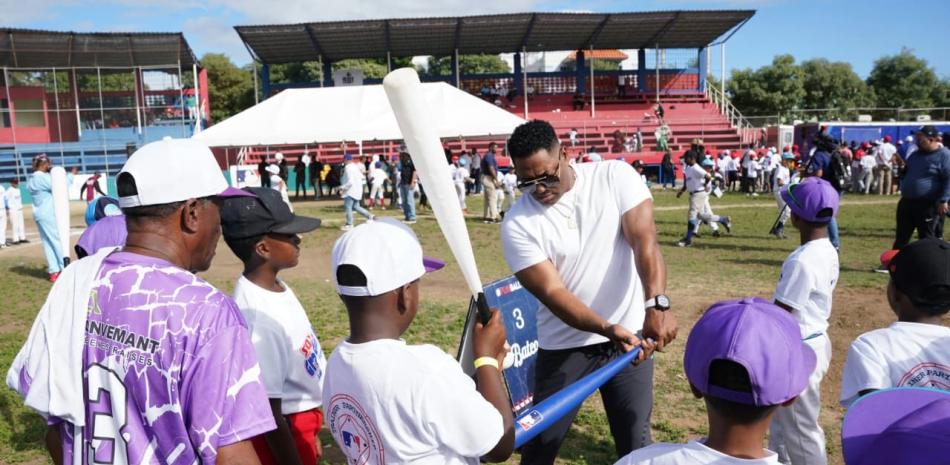 Miguel Tejada, uno de los mejores peloteros dominicanos en Grandes Ligas enseña el arte de batear a varios de los niños que participaron en la actividad.